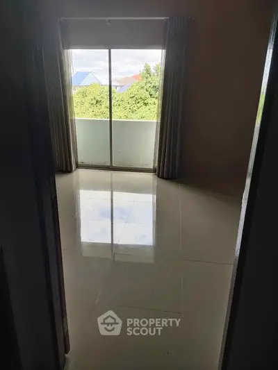 Spacious room with large window offering lush green views, perfect for natural light lovers.