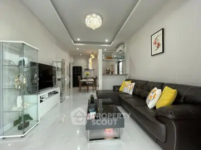 Modern living room with elegant decor, leather sofa, glass display cabinet, and stylish lighting.