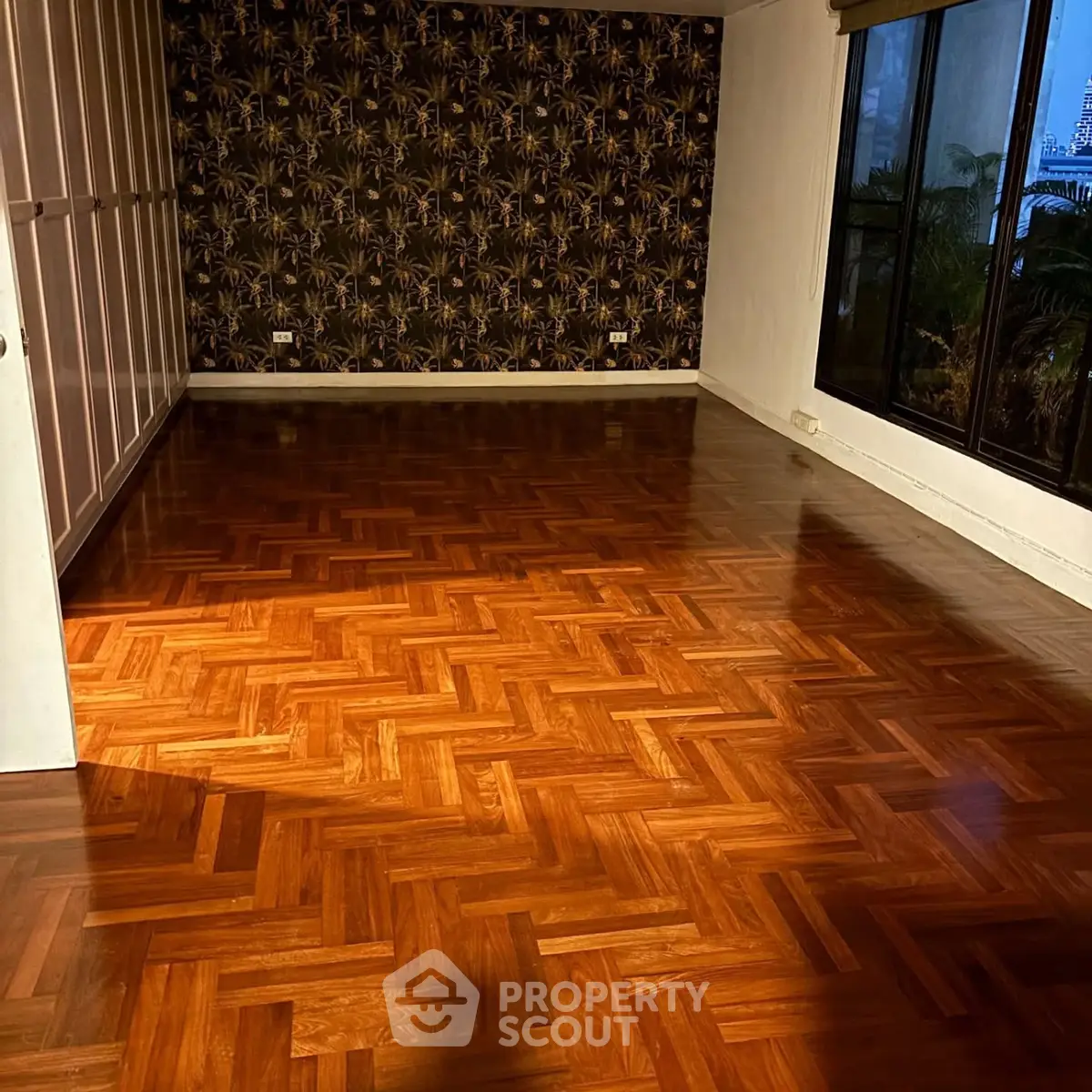 Spacious room with elegant parquet flooring and large windows