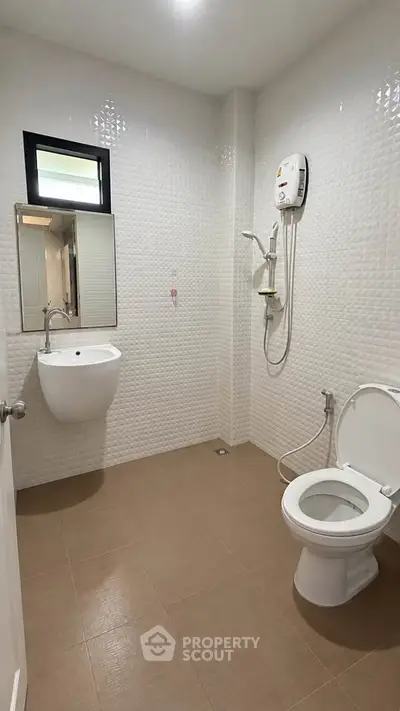 Modern bathroom with sleek fixtures and wall-mounted water heater in a contemporary home.