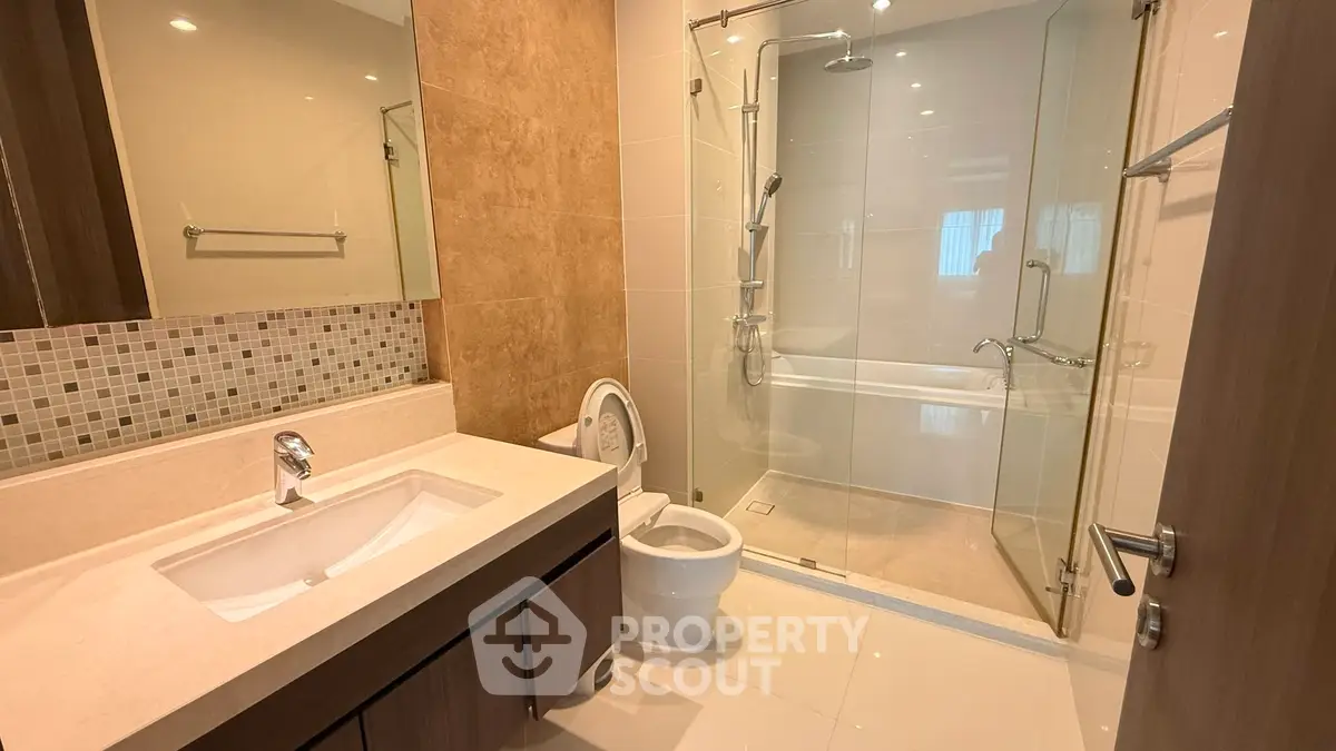 Modern bathroom with glass shower and elegant vanity in luxury apartment