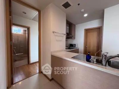 Modern kitchen with open layout and adjacent bathroom in a stylish apartment.