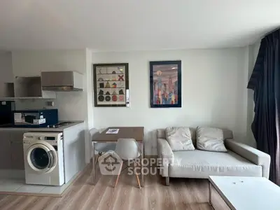 Modern living room with cozy sofa, dining table, and washing machine in open layout apartment.