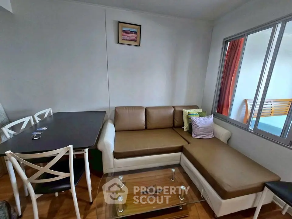 Cozy living room with modern furniture and glass coffee table in a stylish apartment.