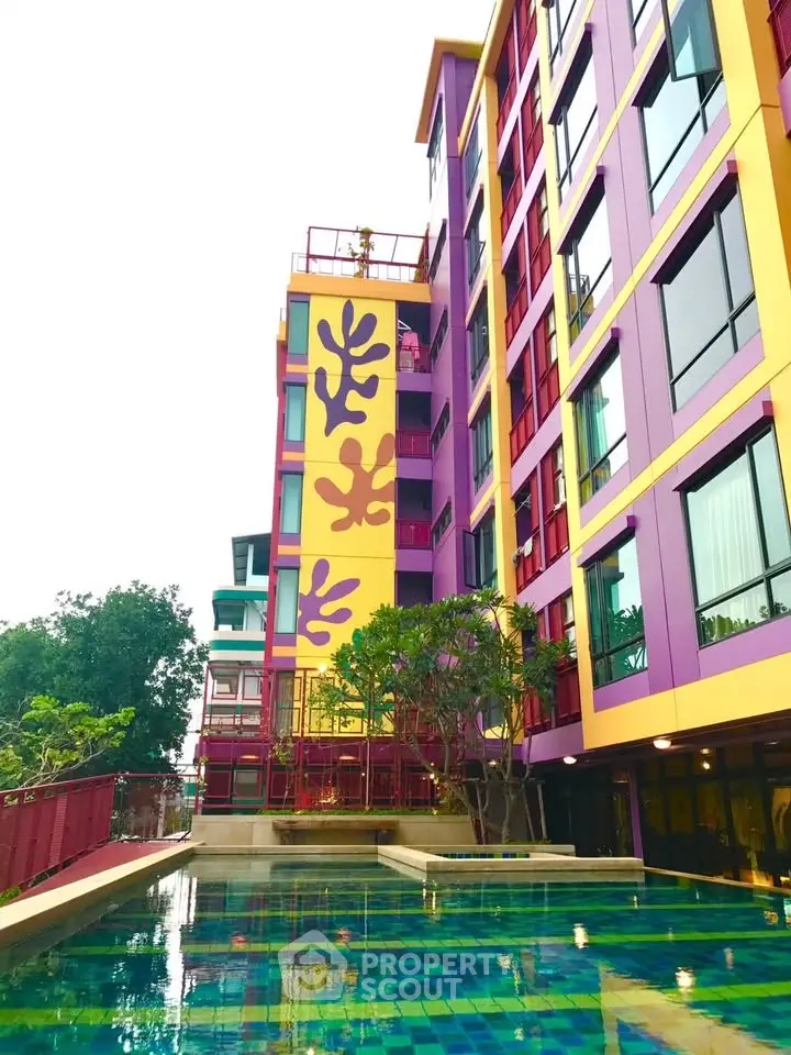 Vibrant modern apartment building with colorful facade and inviting pool area.