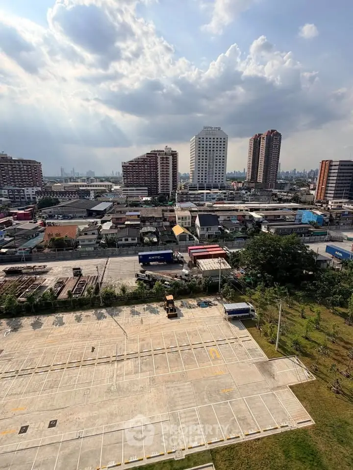 Stunning cityscape view from high-rise building overlooking urban skyline and spacious parking area.
