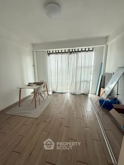 Spacious living room with wooden flooring and natural light