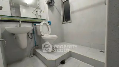 Spacious bathroom with modern fixtures and elevated shower area, perfect for comfort and convenience.