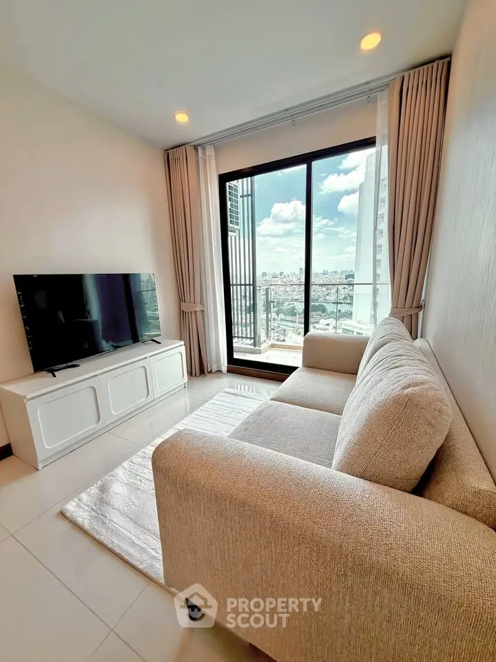 Modern living room with city view, featuring a cozy sofa and large TV, perfect for relaxation.