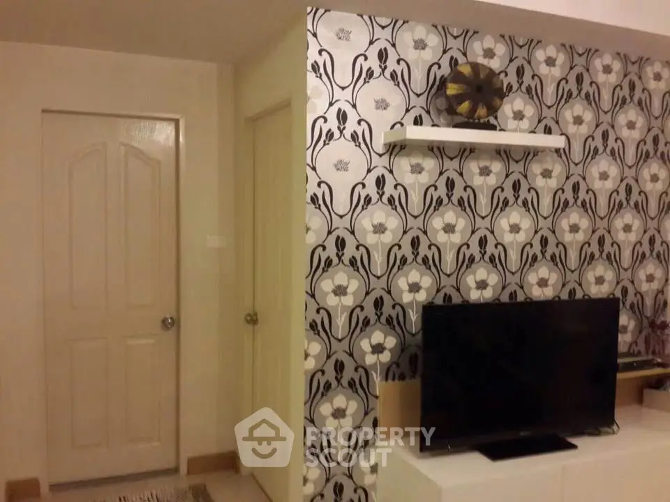 Stylish living room with modern wallpaper and flat-screen TV for cozy entertainment.