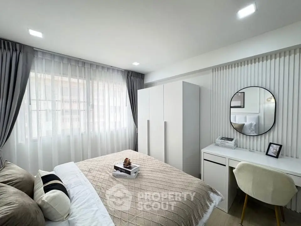 Modern bedroom with stylish decor, featuring a cozy bed, sleek wardrobe, and elegant study area.