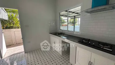 Charming kitchen with gas stove and outdoor access, perfect for culinary enthusiasts.