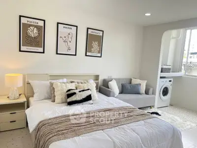 Modern bedroom with cozy decor and in-unit washing machine, perfect for urban living.