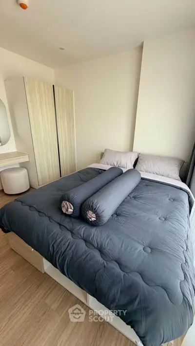 Modern bedroom with stylish decor and cozy bedding in a contemporary apartment.