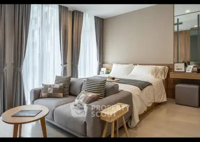 Modern bedroom with cozy seating area and large windows for natural light.