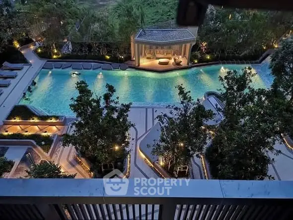 Luxurious outdoor pool area with ambient lighting and lush greenery, perfect for relaxation.