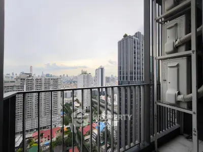 Stunning cityscape view from high-rise balcony with modern railing.