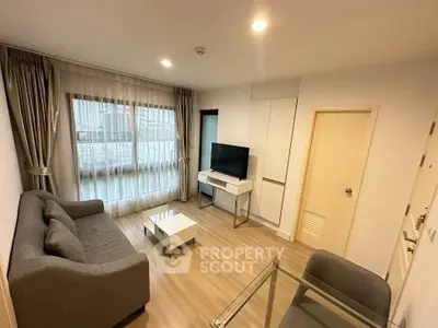 Modern living room with sleek furniture and large window, perfect for cozy relaxation.