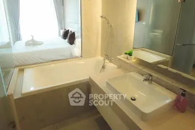 Modern bathroom with elegant fixtures and a view into a cozy bedroom