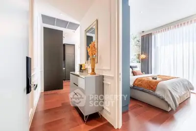 Elegant bedroom with modern decor and natural light, featuring hardwood floors and stylish furniture.
