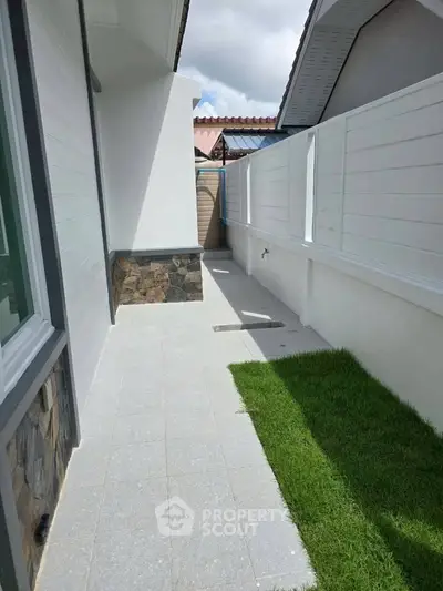Charming outdoor side pathway with modern fencing and lush green grass, perfect for privacy and relaxation.