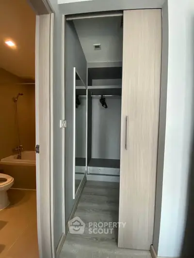 Modern apartment interior with walk-in closet and bathroom view