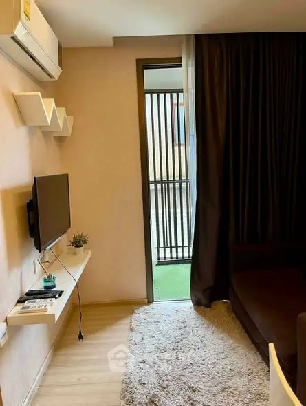 Cozy living room with modern decor and balcony access in a stylish apartment.