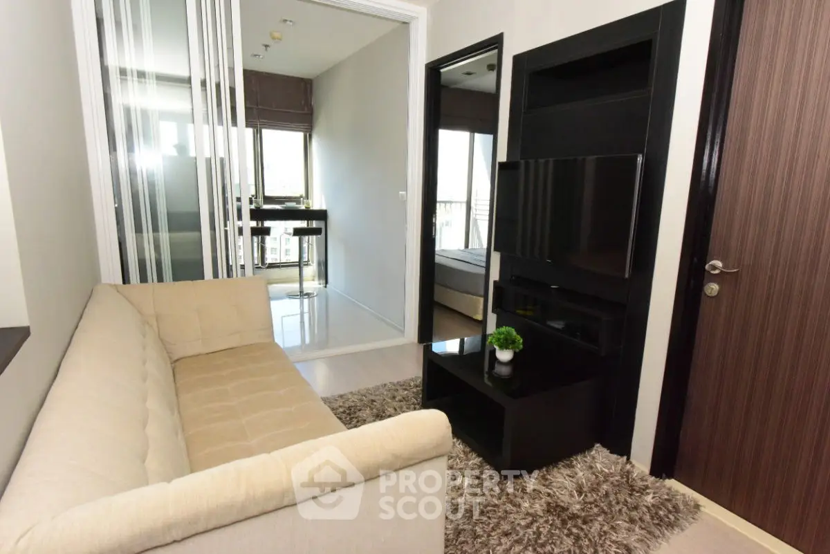 Modern living room with beige sofa and sleek black entertainment unit