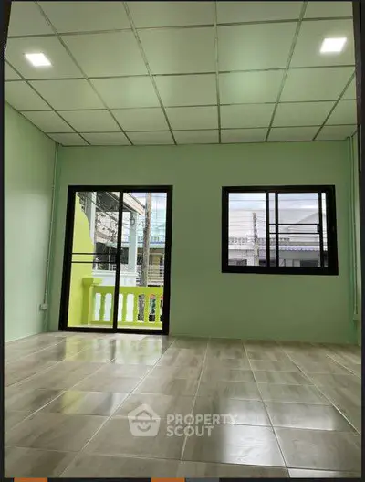 Spacious room with tiled floor and large windows for natural light