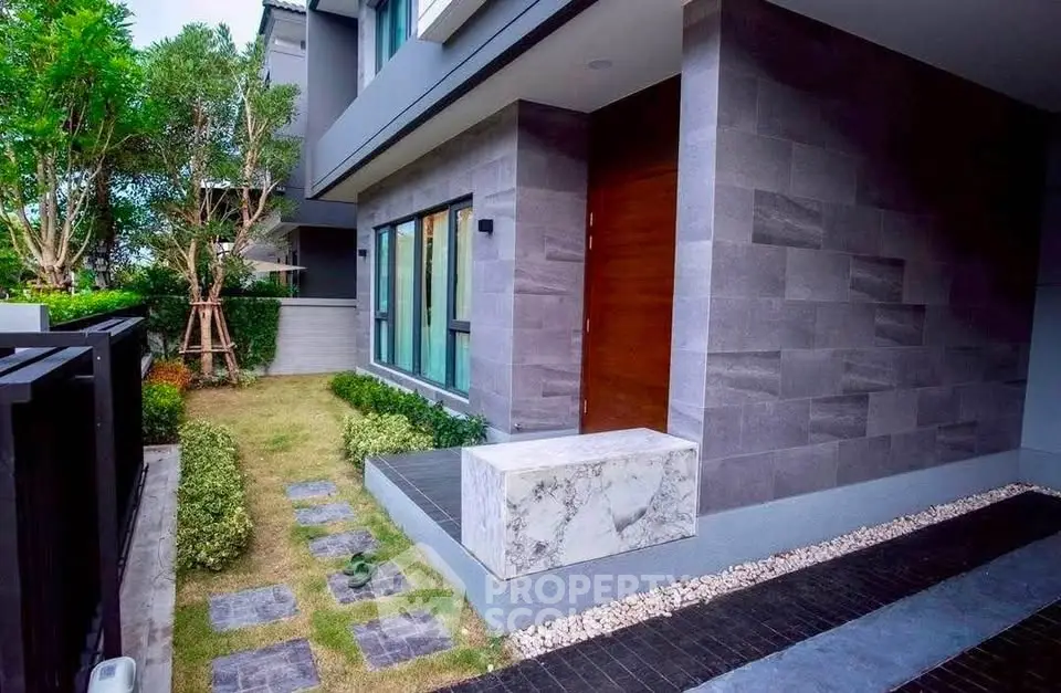 Modern exterior of a stylish home with landscaped garden and sleek stone facade.