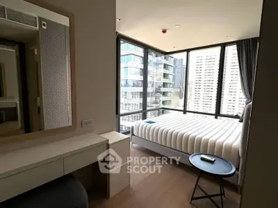 Modern bedroom with floor-to-ceiling windows offering stunning city views, featuring a sleek bed and minimalist decor.