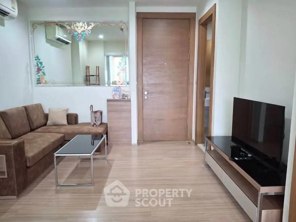 Modern living room with sleek furniture and wooden flooring, featuring a stylish TV unit and comfortable seating.
