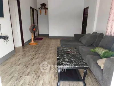 Cozy living room with modern sofa and marble coffee table, ideal for relaxation.