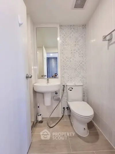 Modern bathroom with elegant tile design and sleek fixtures in a contemporary apartment.