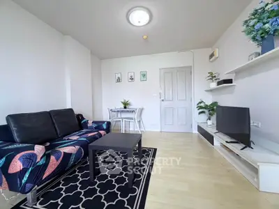 Stylish living room with modern decor and vibrant sofa in a cozy apartment.