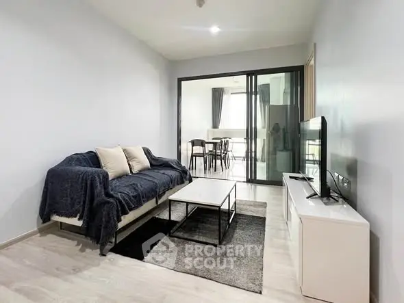 Modern living room with sleek furniture and open layout to dining area