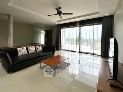 Spacious modern living room with large windows and sleek furnishings