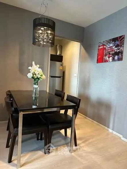 Modern dining area with sleek black table and elegant lighting in stylish apartment.