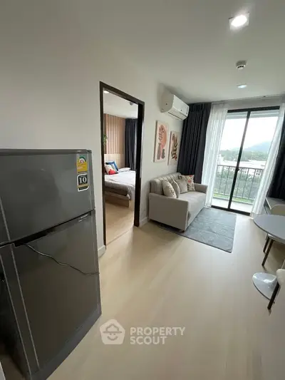 Modern apartment interior with cozy living room and bedroom, featuring a balcony with scenic view.
