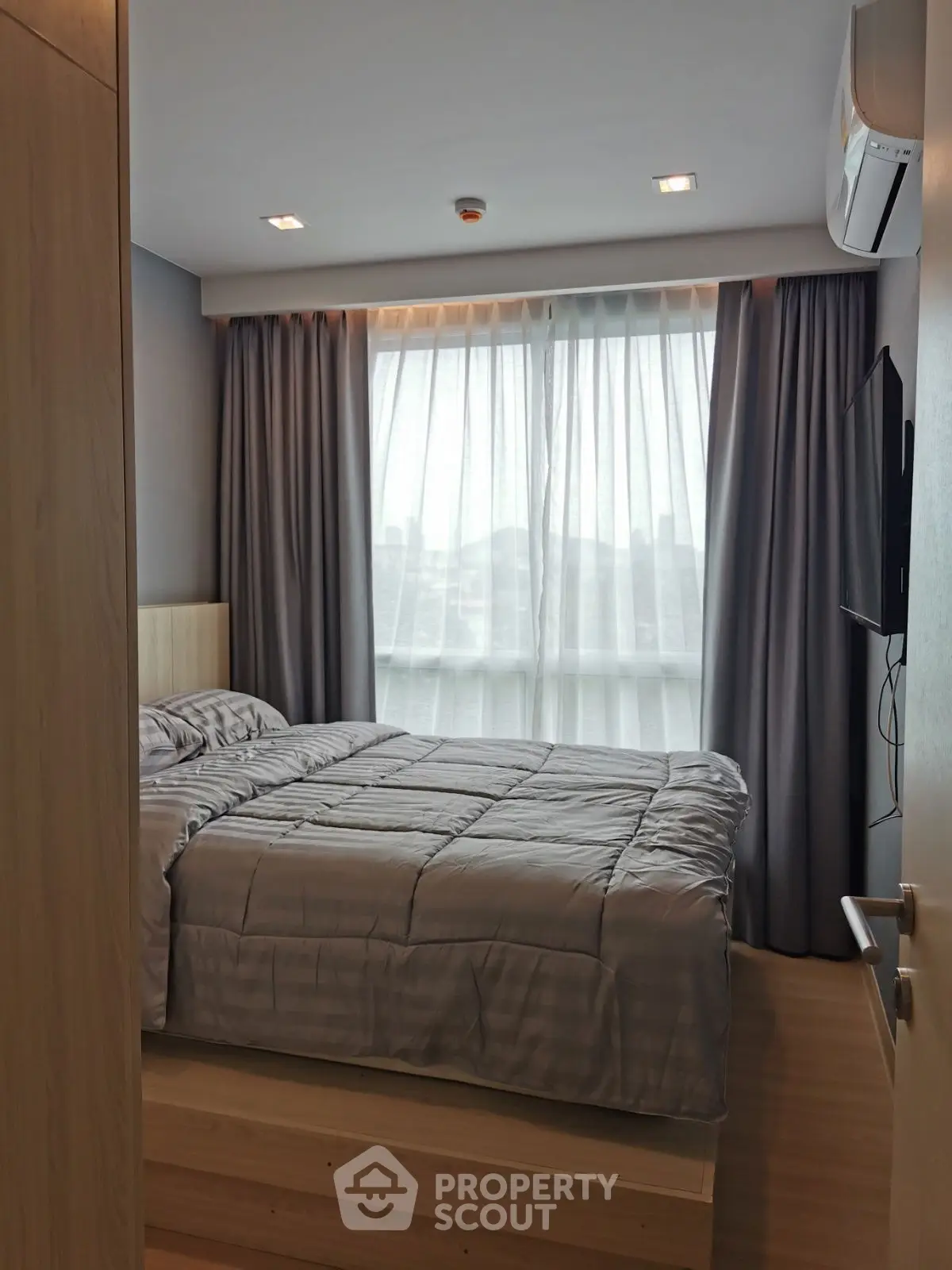 Cozy modern bedroom with large window and stylish curtains