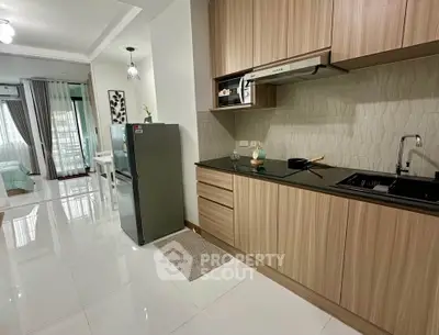Modern kitchen with sleek cabinets and appliances in open layout apartment.