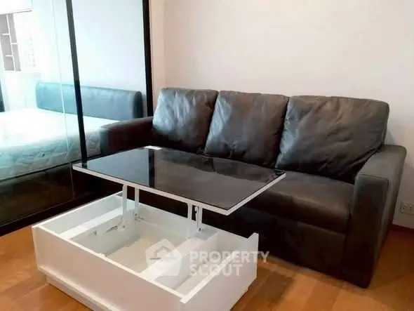 Modern living room with sleek black sofa and innovative lift-top coffee table