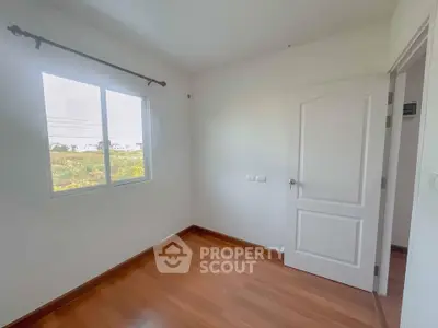 Bright empty room with wooden flooring and large window view