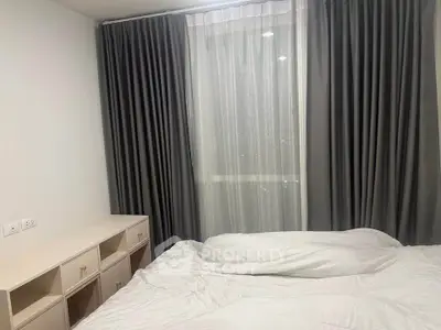 Cozy bedroom with elegant curtains and soft bedding