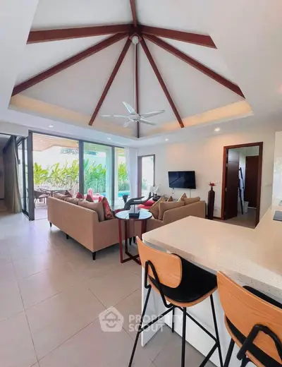 Luxurious open-plan living room with high ceilings and pool view, perfect for modern living.