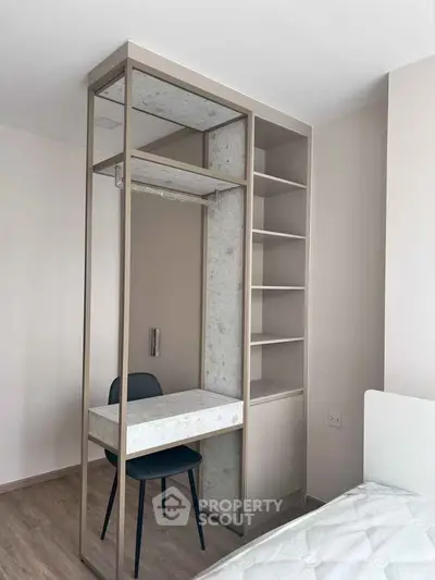 Modern bedroom with built-in desk and shelving, featuring minimalist design and neutral tones.