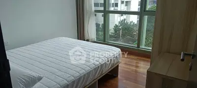 Bright bedroom with large window and wooden flooring in modern apartment