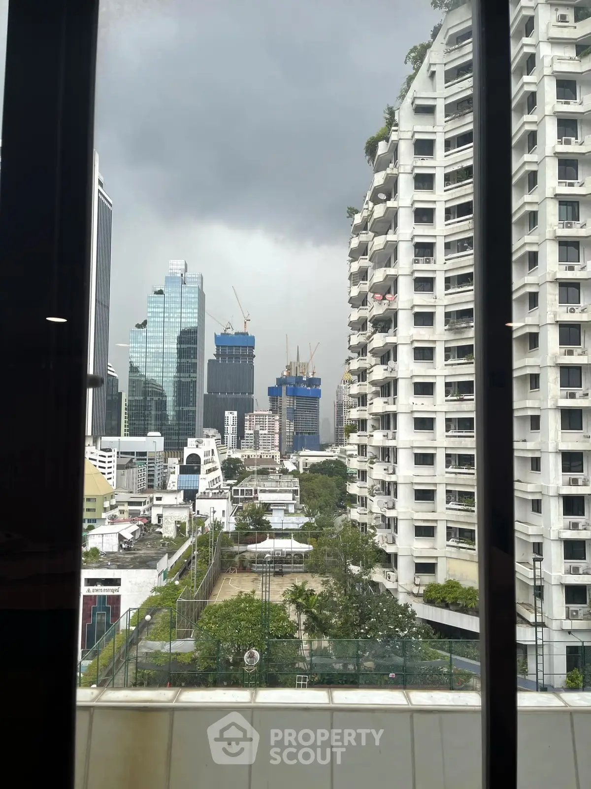 Stunning cityscape view from high-rise window showcasing urban skyline and modern architecture.