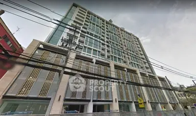 Modern multi-story building with sleek design and large windows in urban setting.