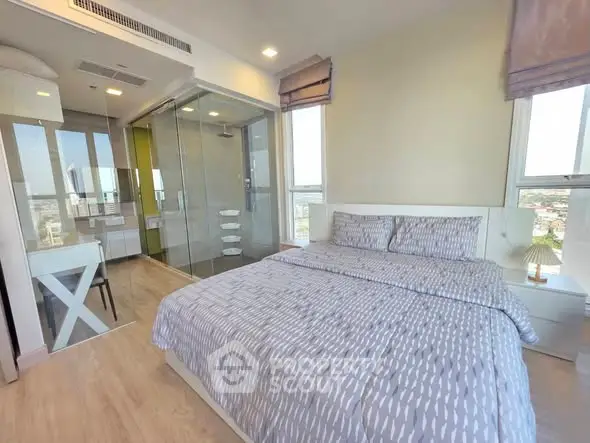 Modern bedroom with ensuite bathroom and city view, featuring stylish decor and ample natural light.